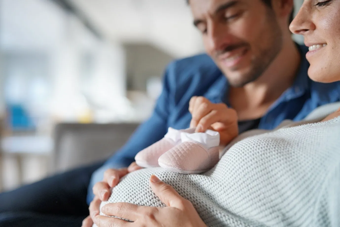 Couple Holding Baby Shoes on a Pregnant Belly